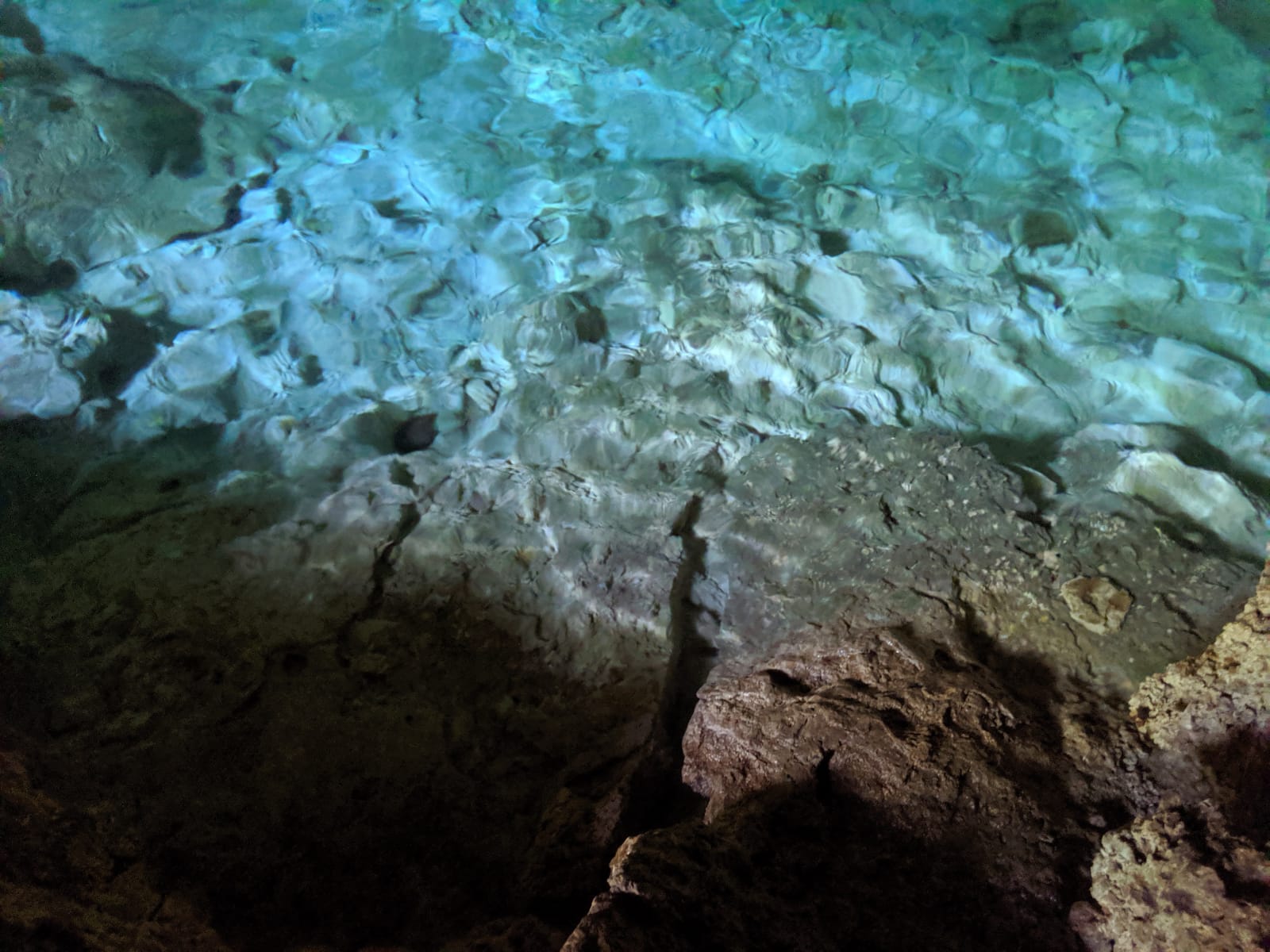 A pool of crystal clear water in an underground cave